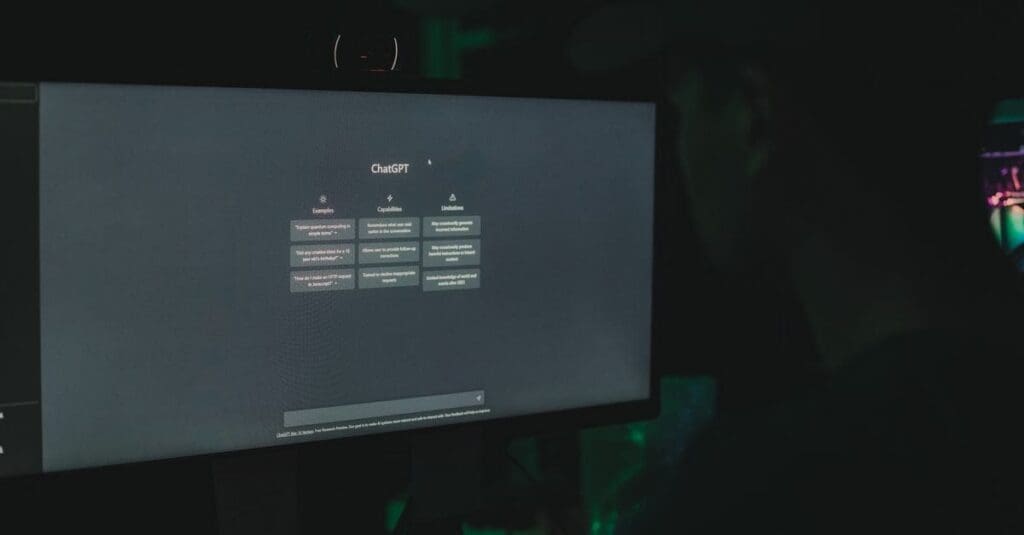 downloaded-image Dimly lit room with a computer monitor showing the ChatGPT interface on screen.