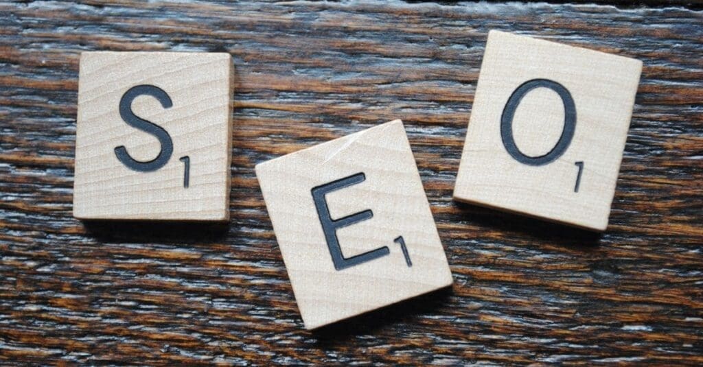 downloaded-image Wooden Scrabble tiles spell SEO on a dark wood surface.